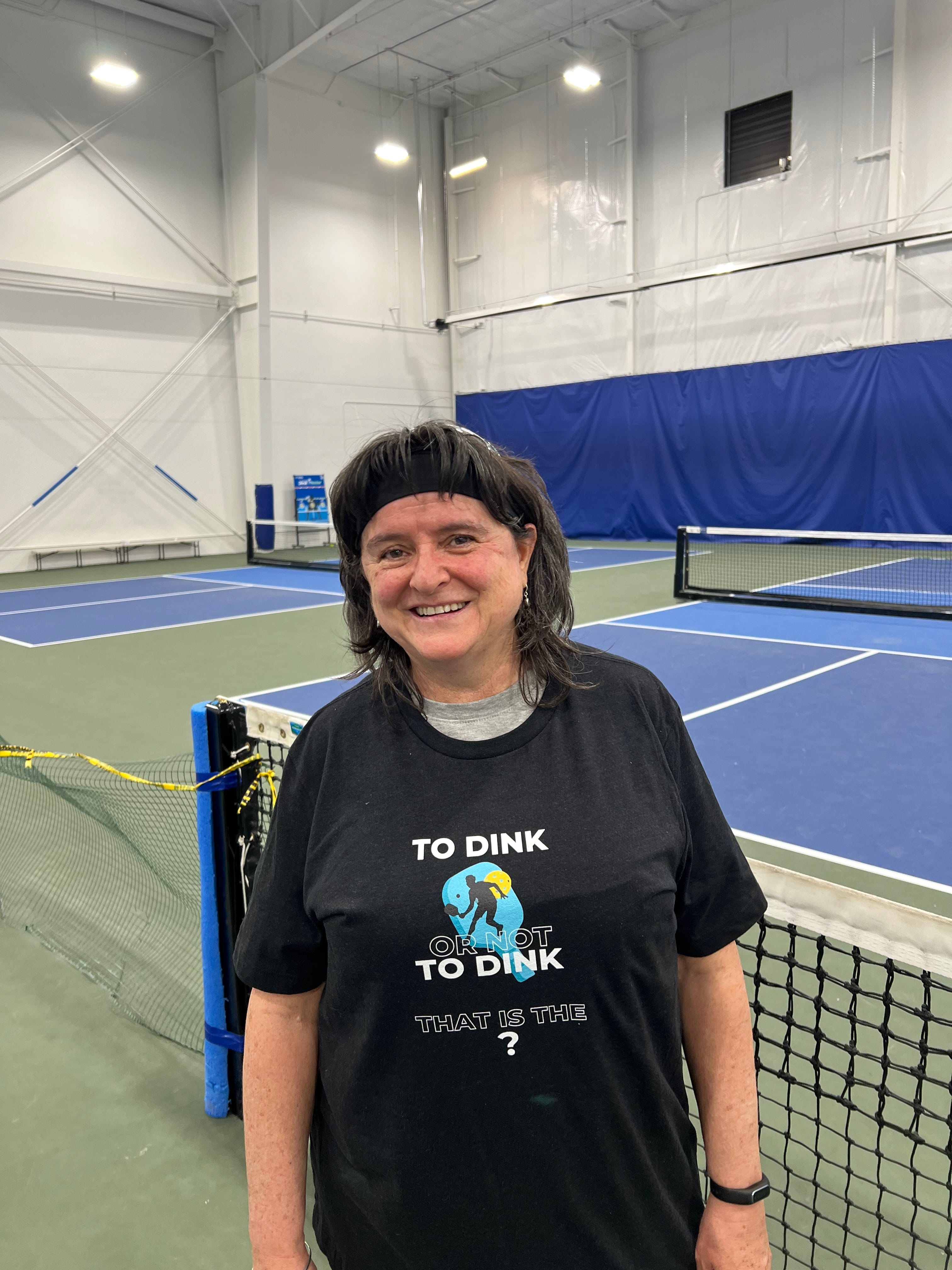 Wendy poses in a Unisex Pickleball T-shirt that says: To Dink or Not to Dink, that is the ?